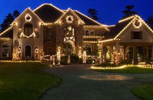 Load image into Gallery viewer, Large house decorated with Christmas lights at night